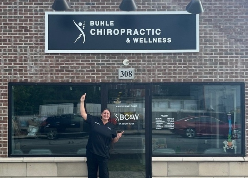 Street View with Dr. Megan Buhle pointing out here new business sign.